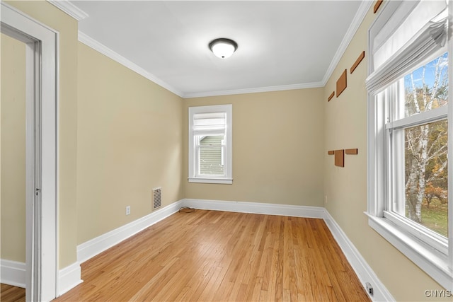 unfurnished room featuring plenty of natural light, light wood-type flooring, and crown molding