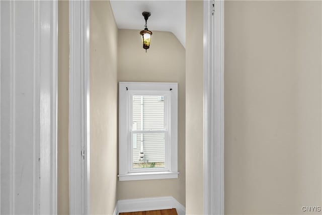 hall with lofted ceiling and hardwood / wood-style flooring