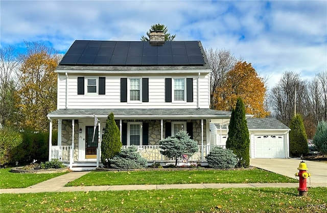 view of front of home with a front yard, a garage, solar panels, and covered porch