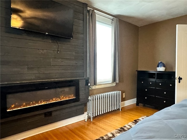 bedroom featuring wood-type flooring and radiator