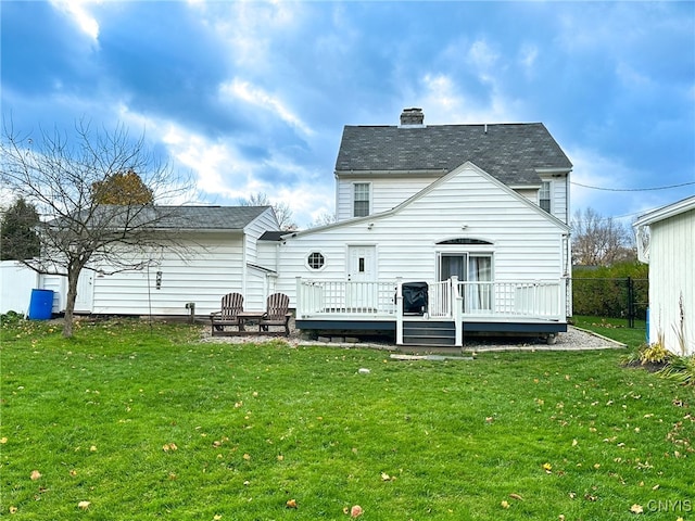 rear view of house with a lawn and a wooden deck