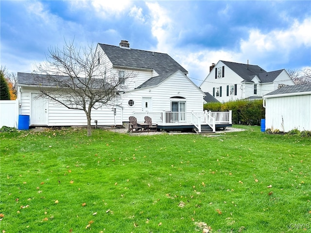 rear view of property featuring a lawn and a wooden deck