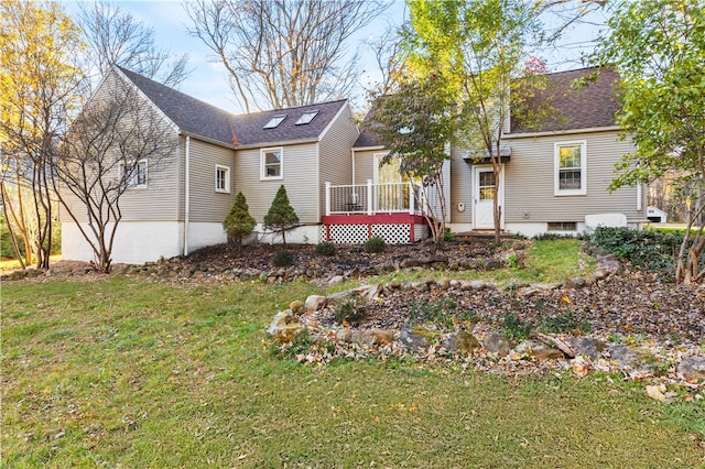 back of house with a wooden deck and a lawn