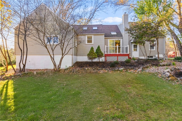 rear view of property featuring a garage and a yard