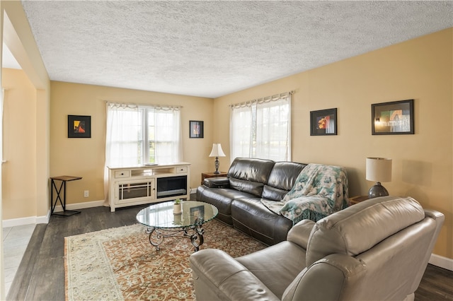 living room with dark wood-type flooring and a textured ceiling