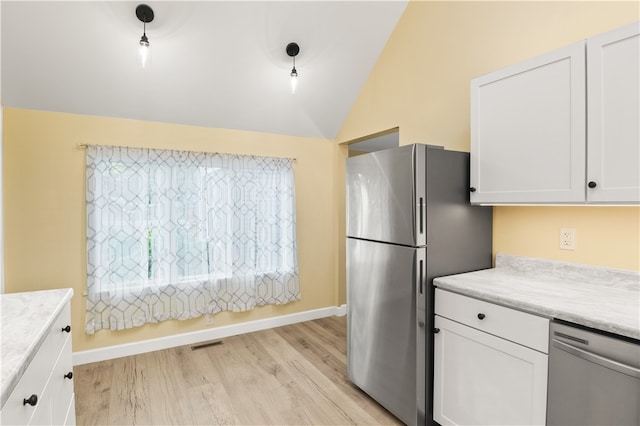 kitchen with appliances with stainless steel finishes, lofted ceiling, light hardwood / wood-style floors, and white cabinets