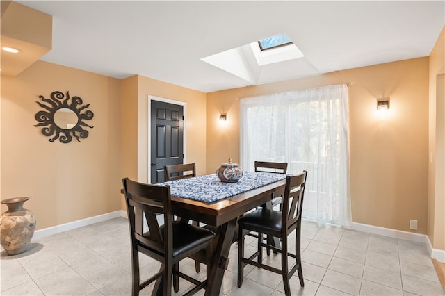 dining room with light tile patterned floors and a skylight