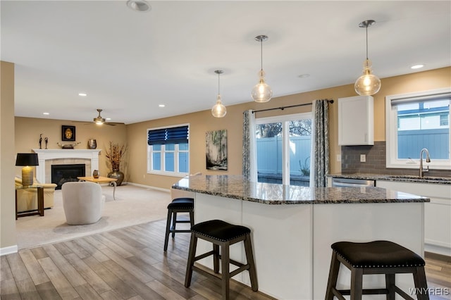 kitchen featuring white cabinetry, a healthy amount of sunlight, sink, and decorative light fixtures