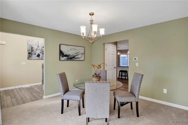 carpeted dining space with an inviting chandelier