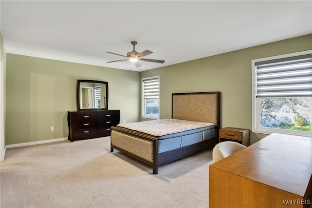 bedroom with light colored carpet, multiple windows, and ceiling fan