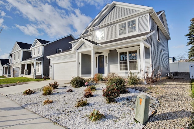 view of front of property with central AC, covered porch, and a garage