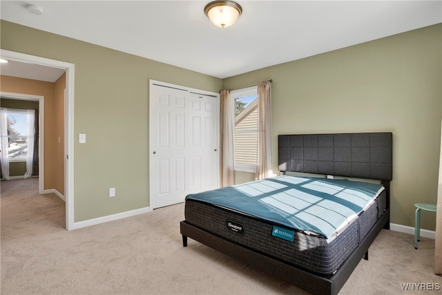 bedroom featuring light colored carpet, multiple windows, and a closet