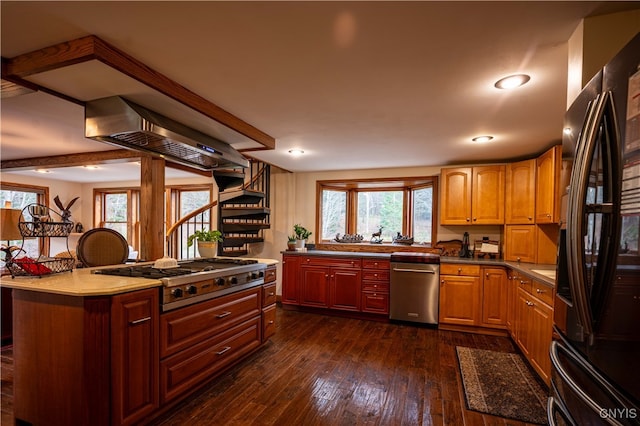 kitchen with dark hardwood / wood-style flooring, range hood, appliances with stainless steel finishes, and a center island