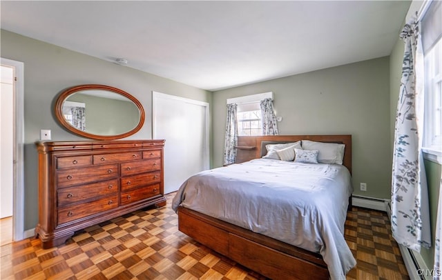 bedroom featuring baseboard heating and parquet flooring