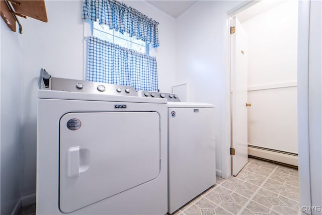 washroom with baseboard heating, light tile patterned flooring, and washing machine and clothes dryer