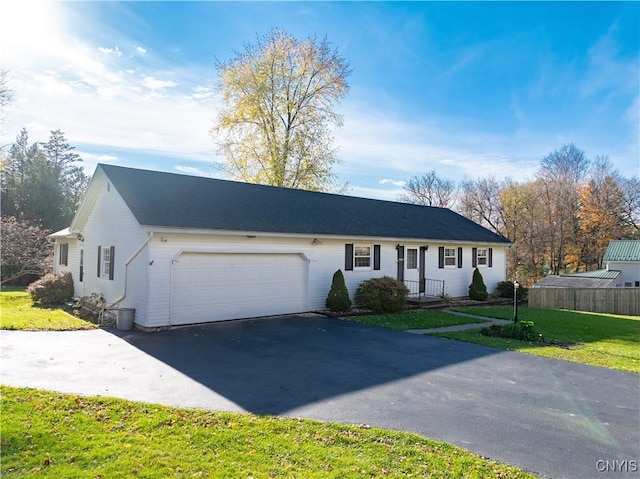 ranch-style home featuring a front lawn and a garage