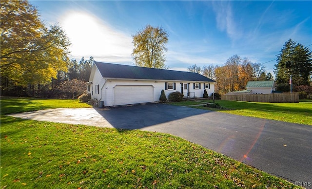 single story home featuring a garage and a front yard