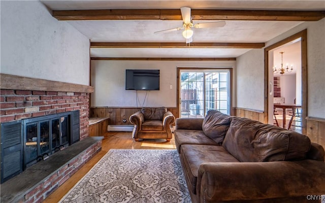 living room with light wood-type flooring, a brick fireplace, baseboard heating, and ceiling fan