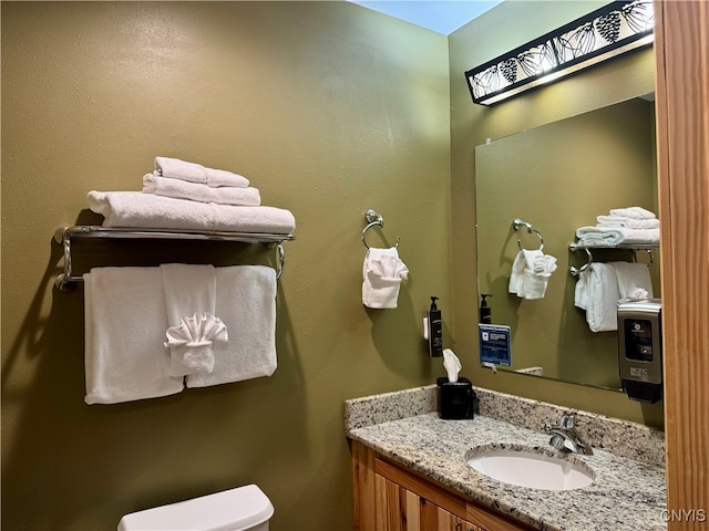 bathroom with toilet, vanity, and a skylight