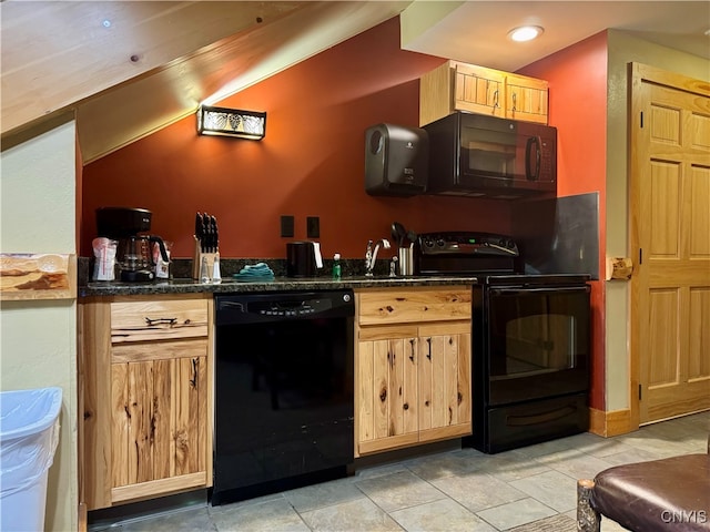 kitchen featuring black appliances, light brown cabinetry, and dark stone countertops