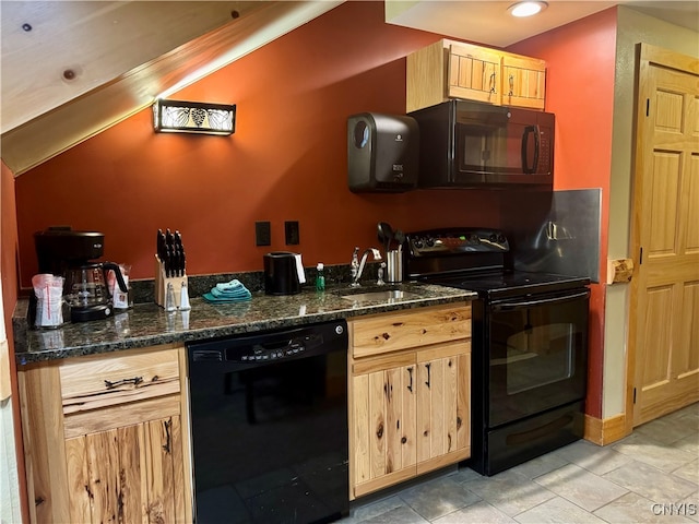 kitchen featuring dark stone counters, light brown cabinetry, and black appliances