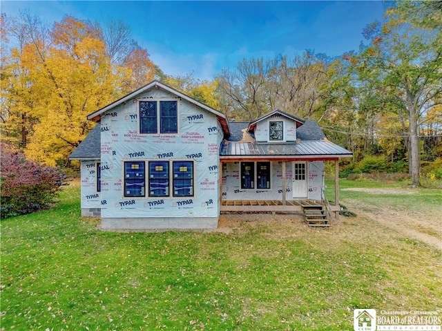 back of house featuring a lawn and covered porch