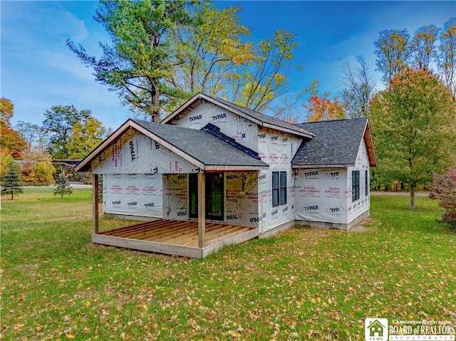 back of house with a deck and a yard