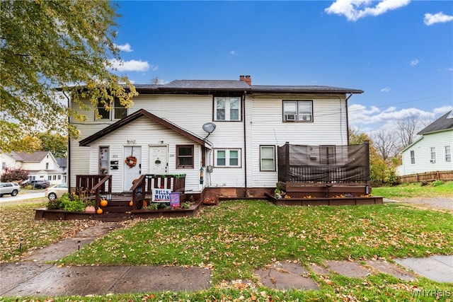 back of house featuring a lawn and a deck