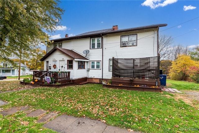 rear view of property featuring a yard and a deck