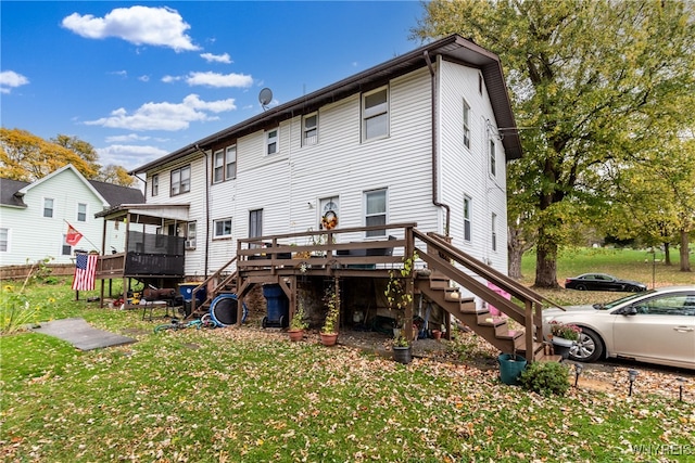 rear view of property featuring a yard and a deck