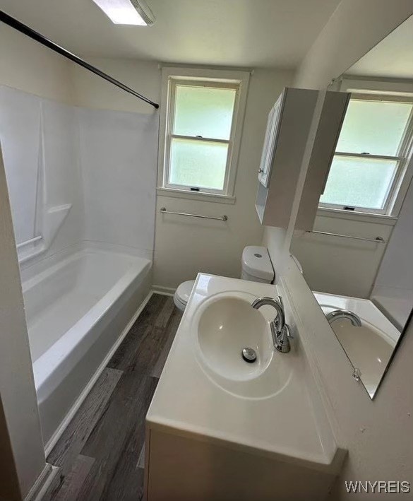 full bathroom with toilet, vanity, shower / bathtub combination, and wood-type flooring