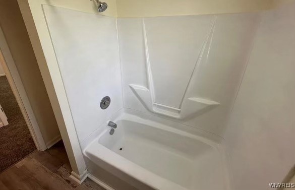 bathroom with wood-type flooring and shower / bathing tub combination