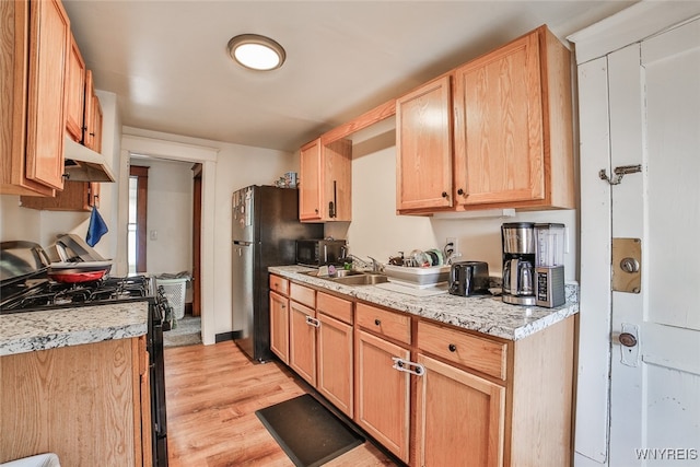 kitchen with light brown cabinets, black range with gas cooktop, and light wood-type flooring