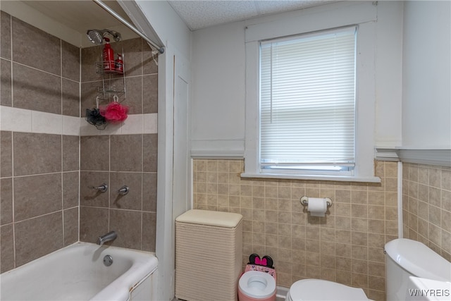 bathroom with plenty of natural light, tile walls, and tiled shower / bath combo