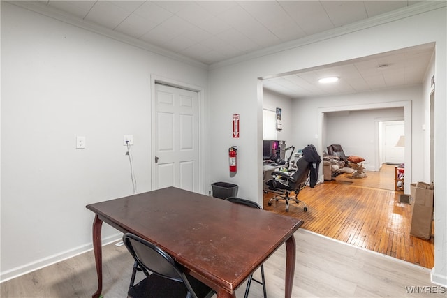 office with light hardwood / wood-style floors and crown molding