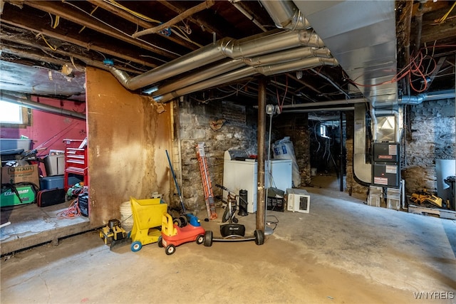 basement featuring heating unit and washer / clothes dryer