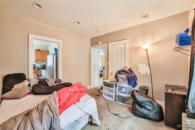 bedroom with carpet and stainless steel refrigerator