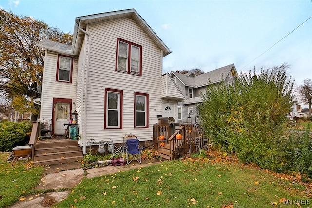 back of house featuring a deck and a lawn