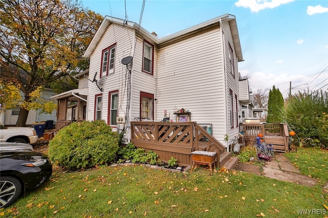 rear view of house with a yard and a deck