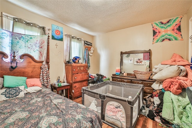 bedroom featuring hardwood / wood-style floors and a textured ceiling