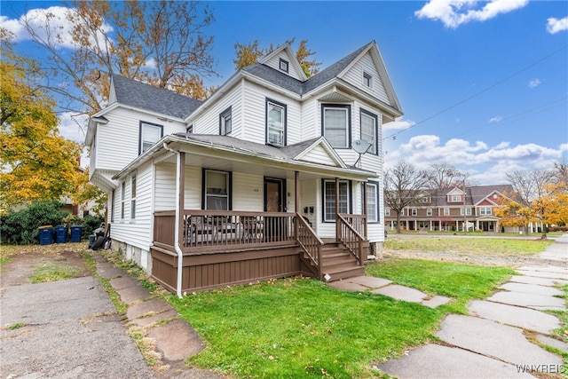 view of front of property with a porch and a front lawn