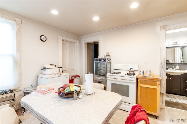 kitchen with oven, sink, white gas stove, and washer / dryer