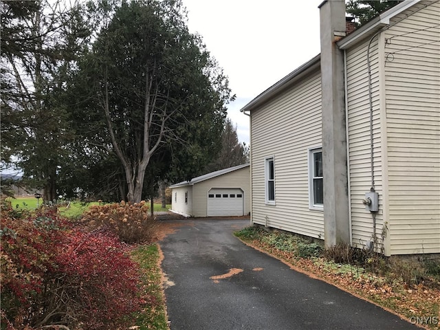 view of home's exterior featuring a garage and an outbuilding