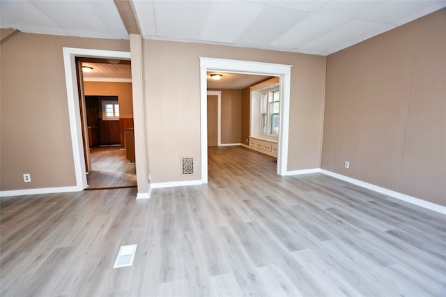 unfurnished room with light hardwood / wood-style floors and crown molding