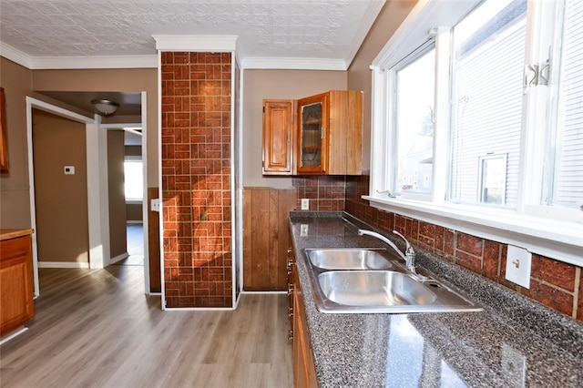 kitchen featuring a textured ceiling, crown molding, light wood-type flooring, and sink