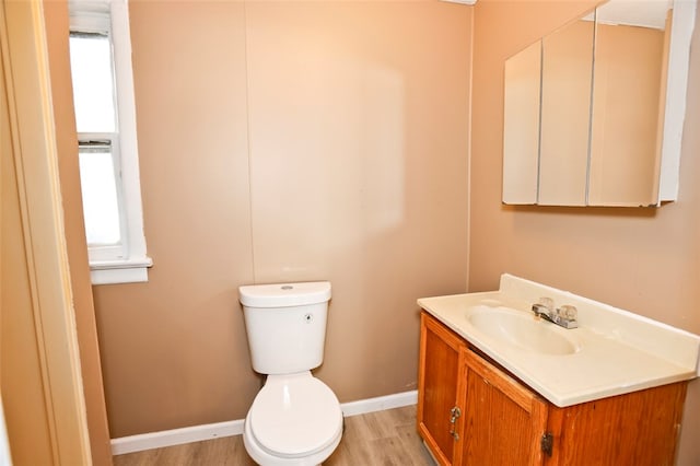 bathroom featuring plenty of natural light, vanity, wood-type flooring, and toilet