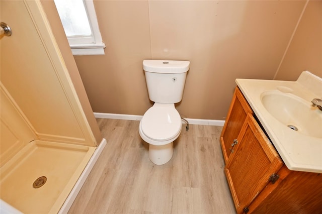 bathroom with wood-type flooring, vanity, toilet, and walk in shower