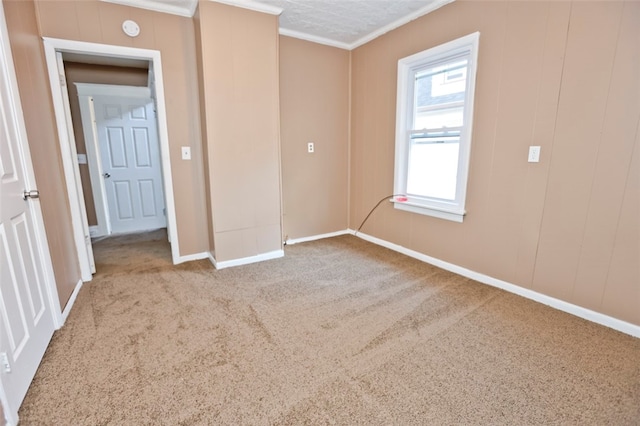 carpeted empty room featuring ornamental molding and a textured ceiling