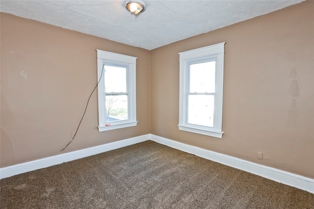 spare room featuring carpet and a textured ceiling