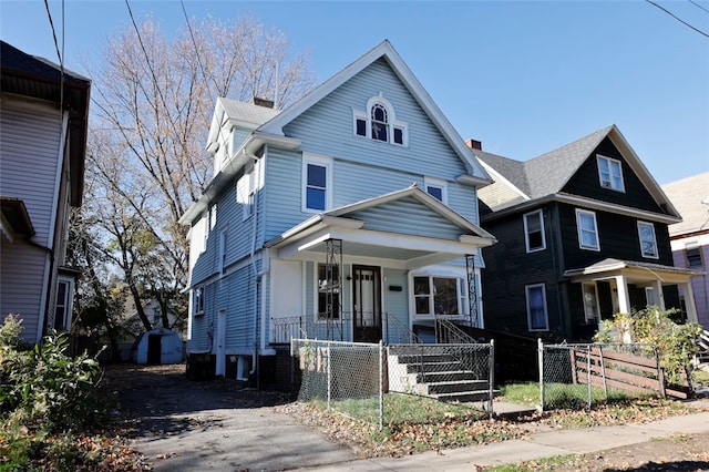 view of front facade featuring covered porch and a storage shed